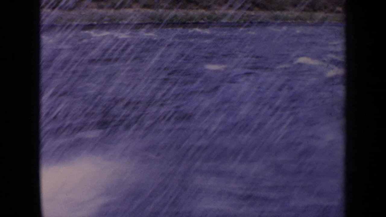 1963 Idaho 8mm frame showing fast blue water and spray, seen from a passing window-like viewpoint.