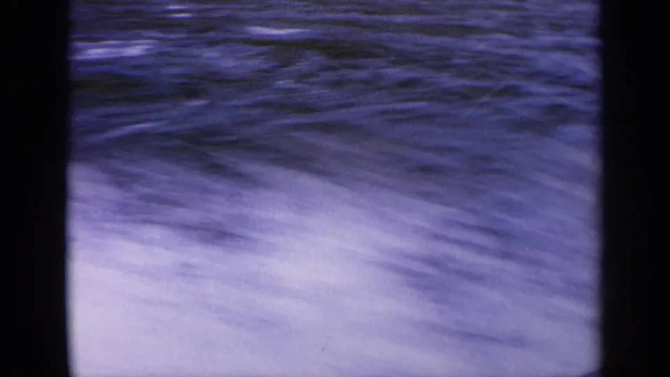 1963 Idaho 8mm frame showing fast-moving water with pale spray and dark vertical film borders.