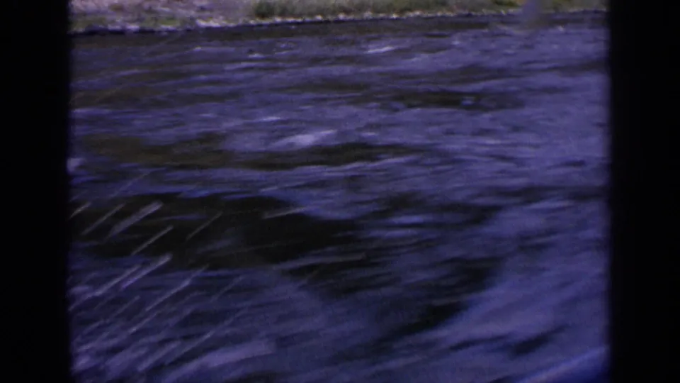1963 Idaho 8mm frame with dark rippled water and a small visible shoreline band near the top edge.