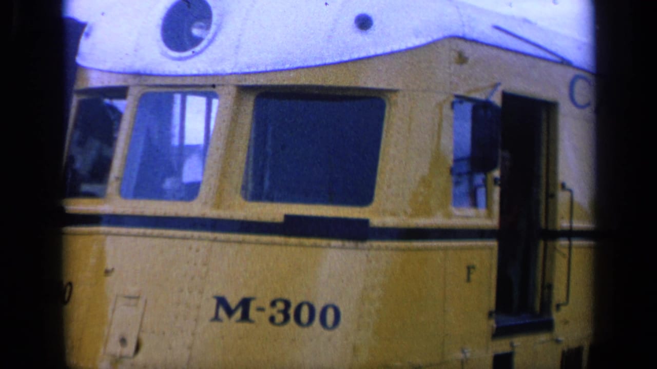 Close view of a yellow streetcar marked M-300 with dark windows and an open side door.