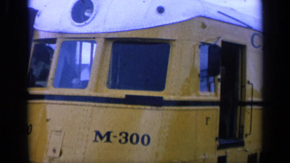 1963 San Francisco home-movie frame showing a yellow M-300 streetcar in close view, with dark windows and an open side door.