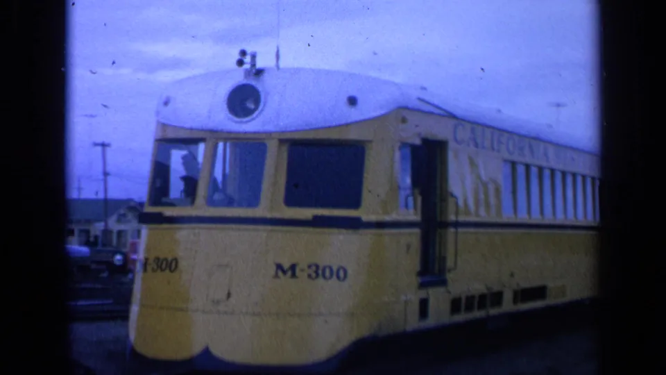 Wider 1963 San Francisco view of the yellow M-300 streetcar, showing more of the side windows and nearby power lines.