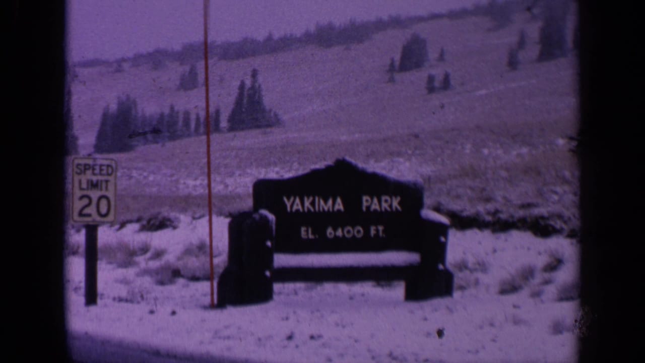 Yakima Park sign beside a speed-limit sign in a snowy landscape.