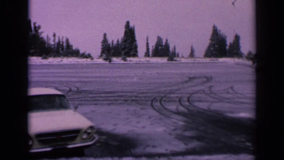 Final frame shows the white car partly cropped at lower left, with frozen roadway, looping tire tracks, and evergreen trees in Washington.