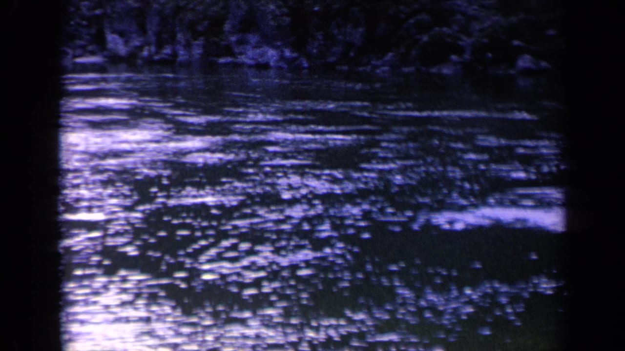 Rippling river water with scattered highlights and dark vertical frame shadows.