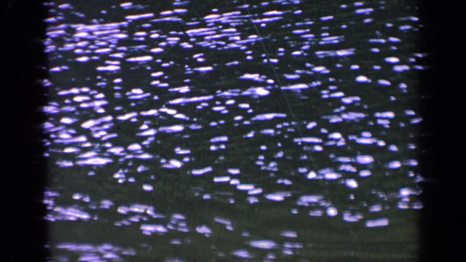 1963 8mm Washington home-movie frame of rippling water with dense sparkling reflections and dark rounded frame edges.