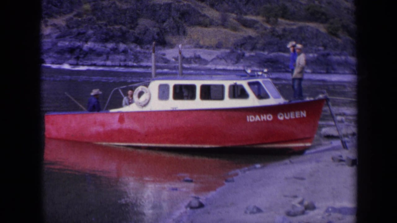 The IDAHO QUEEN fills the frame in 1963 Washington footage, with a man standing near the stern and others near the cabin.