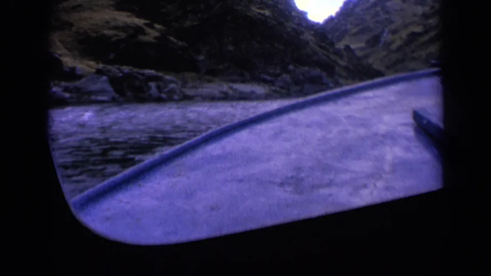 1963 Washington 8mm boating view with the deck edge in the foreground and steep canyon walls enclosing the waterway.