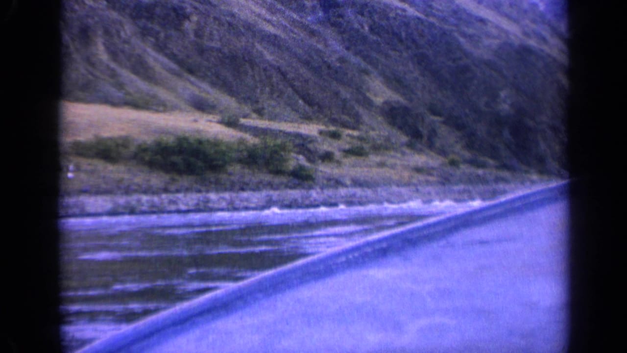 1963 Washington vessel view looking along rippled river water toward sloping hillsides and a low shoreline.