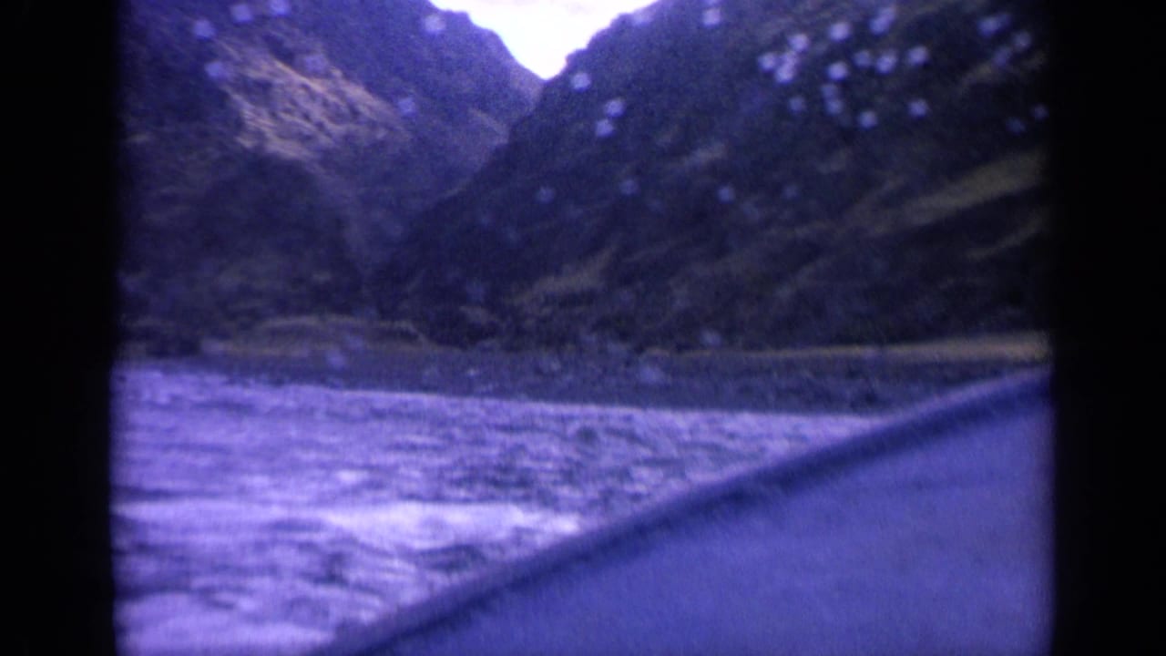 1963 Washington 8mm view from a boat moving through a narrow waterway between steep, forested slopes.