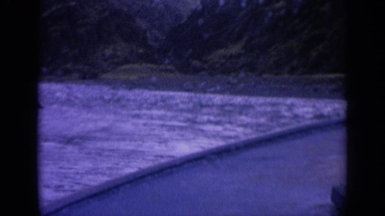 River rapids seen from a boat with shoreline in the distance.