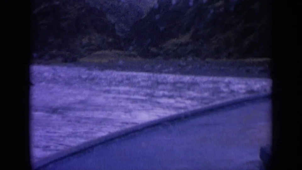 Purple-shifted 8mm frame from Washington showing fast river water beside the edge of a moving boat.