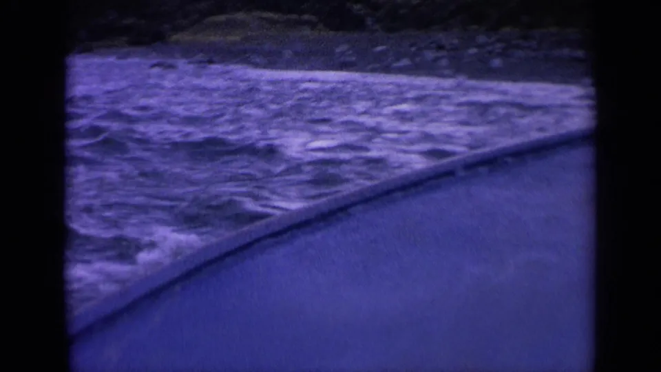 8mm Washington river frame showing whitewater rapids next to a boat edge, tinted purple by aged film color.