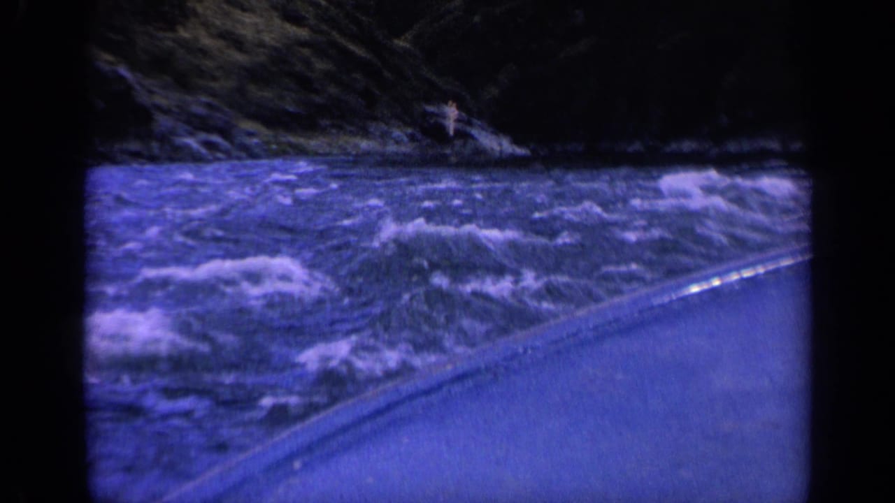 Fast river current and white foam beside a boat edge under dark low-light conditions.