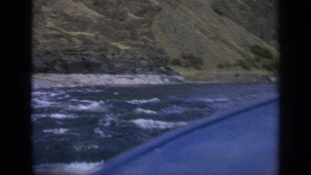 Choppy river current seen past the edge of a moving boat.
