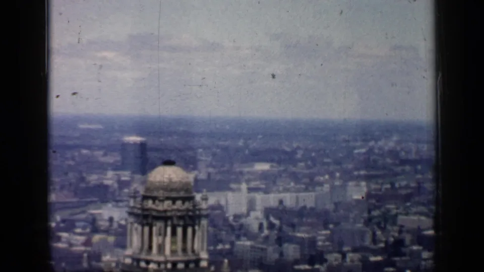 1957 Chicago skyline frame with a prominent domed tower in front of distant city blocks and haze.