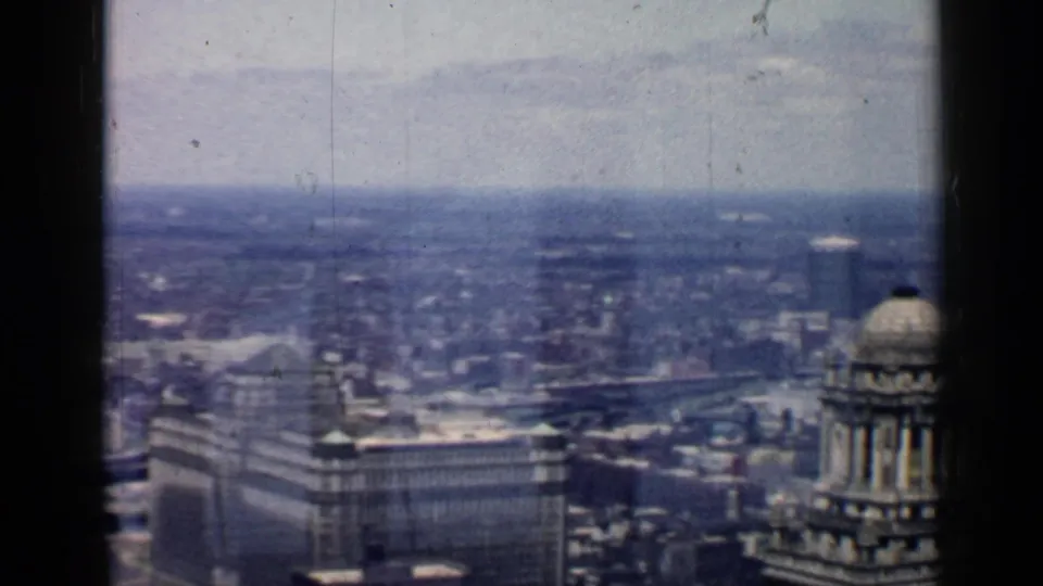 Final 1957 Chicago skyline frame with a large foreground building, partial domed tower, and distant urban haze.