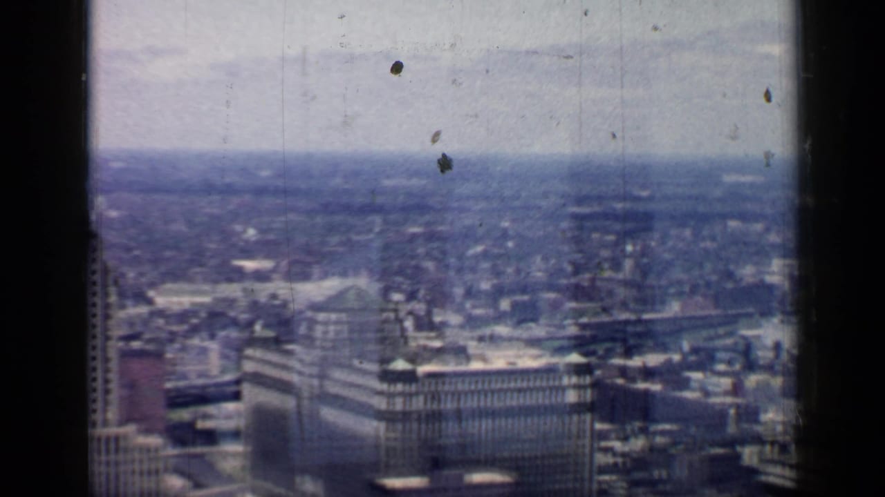 Downtown Chicago skyline seen through a dark window frame with hazy sky above.