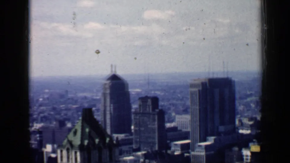 1957 Chicago view with a green-roofed foreground building, downtown towers, and a hazy urban distance.