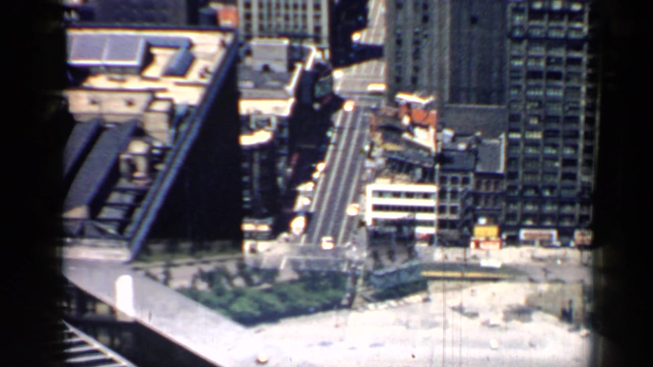 High-angle view of downtown buildings, shoreline road, and Lake Michigan waterfront.