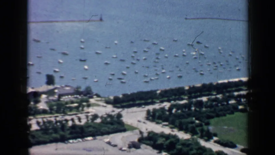 1957 Chicago shoreline view with clustered boats on Lake Michigan, broad roads, trees, and park space below.