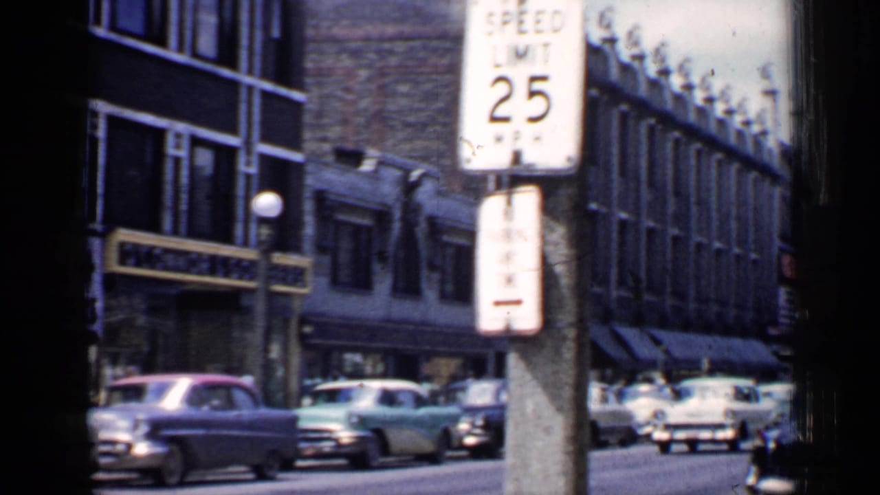 Chicago street with mid-century cars, brick buildings, and a 25 mph speed limit sign.