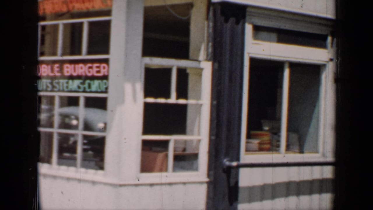 Diner storefront window with neon lettering for burgers and steaks.