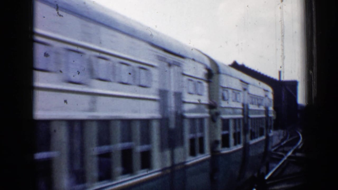 Passenger train car passing beside a station window or platform edge.