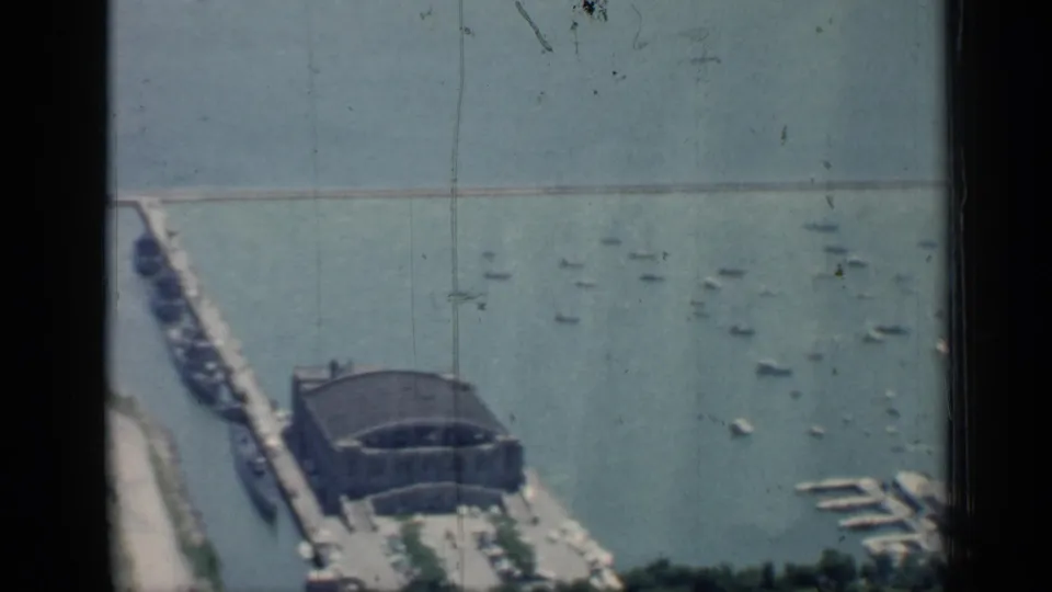 1958 Chicago harbor view from above, showing a domed pier building, long breakwater, marina docks, and small boats on the water.