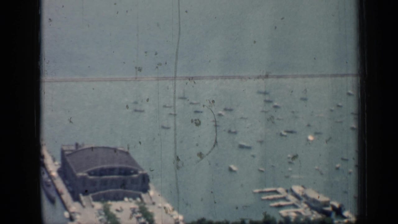 Harbor and pier seen from above with many small boats scattered on the water.
