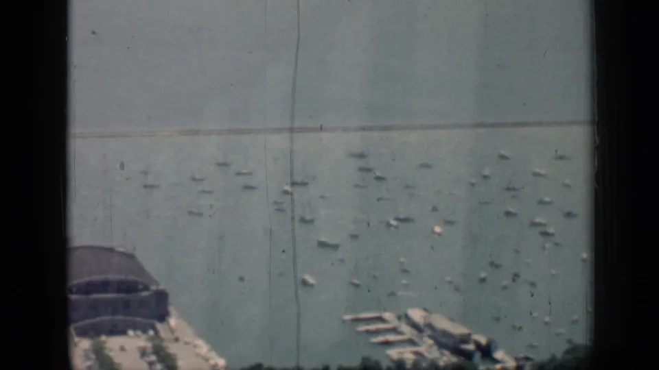 High-angle Chicago lakefront harbor frame from 1958, with the pier building partly cropped, small boats, and marina docks below.
