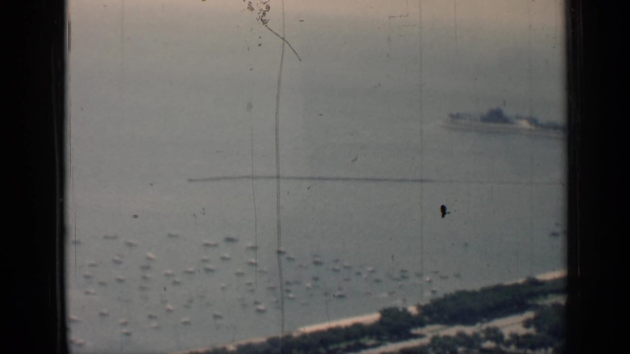 A high-angle 1958 Chicago lakefront view shows scattered small boats, a distant linear pier or breakwater, and shoreline at the bottom edge.