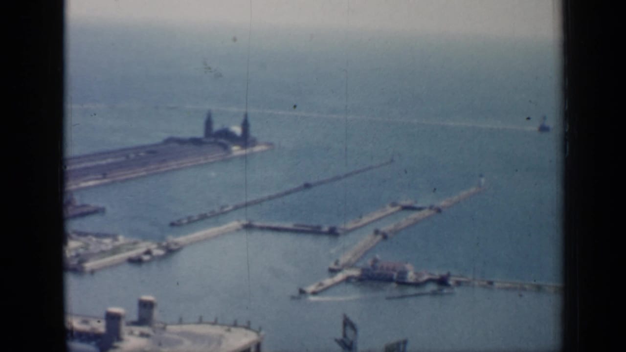 Harbor piers and breakwaters extend into blue water from an elevated view.