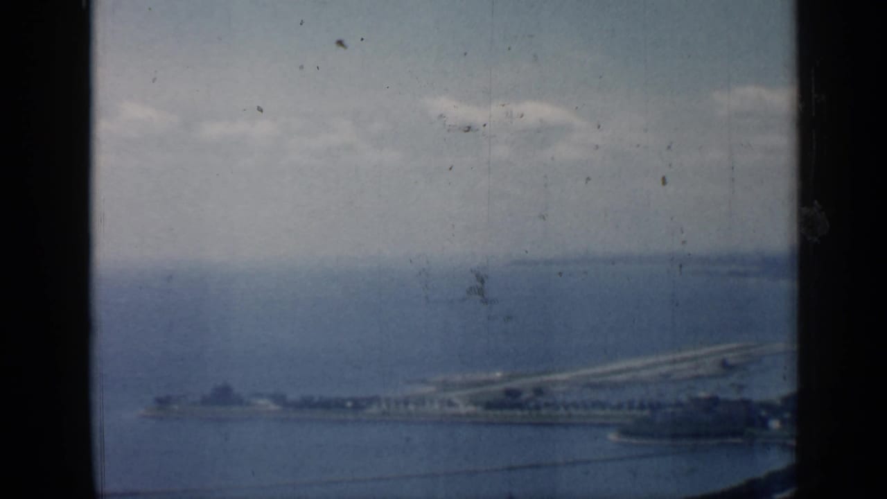 Chicago-area lakefront view from 1958, showing a long pier or breakwater beside blue water and a hazy horizon.