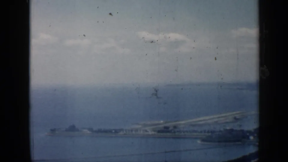 Chicago-area lakefront view from 1958, showing a long pier or breakwater beside blue water and a hazy horizon.