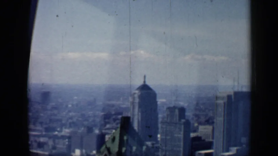 Soft 8mm view across the Chicago skyline, with a domed tower shape, surrounding high-rises, and a distant urban horizon.