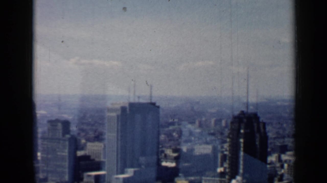 Skyline and high-rise buildings framed by vertical window mullions.