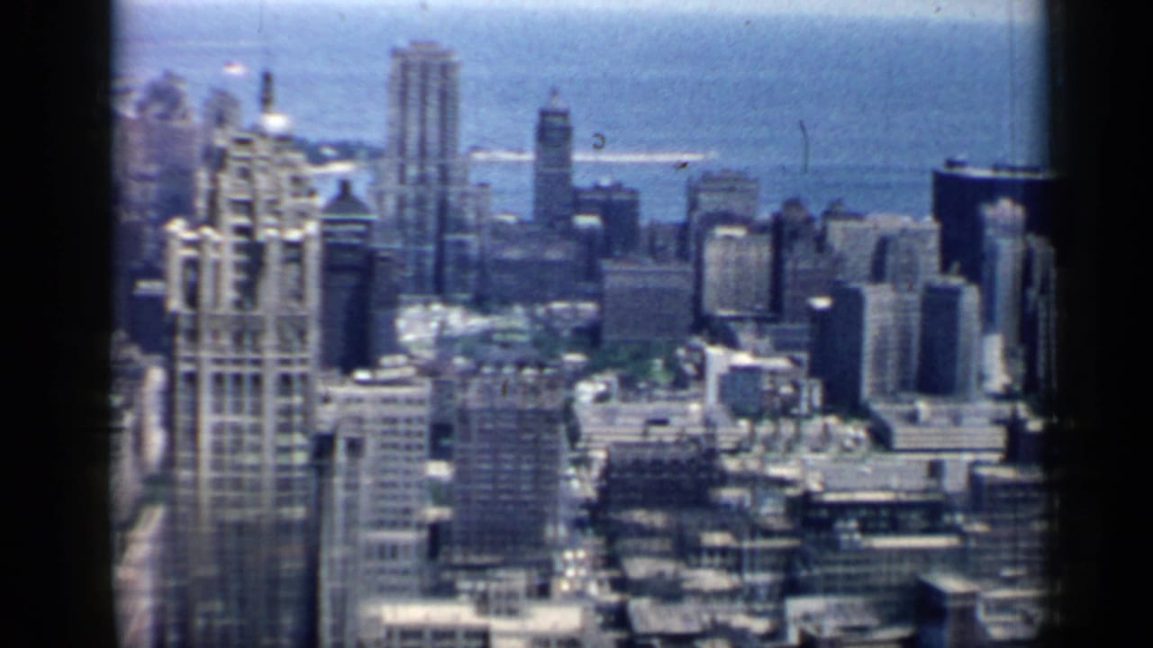 Chicago skyline in 1958, with clustered high-rises, rooftop detail, and Lake Michigan behind the city.