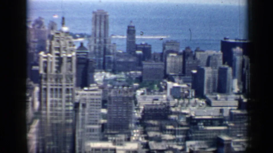 Chicago skyline in 1958, with clustered high-rises, rooftop detail, and Lake Michigan behind the city.