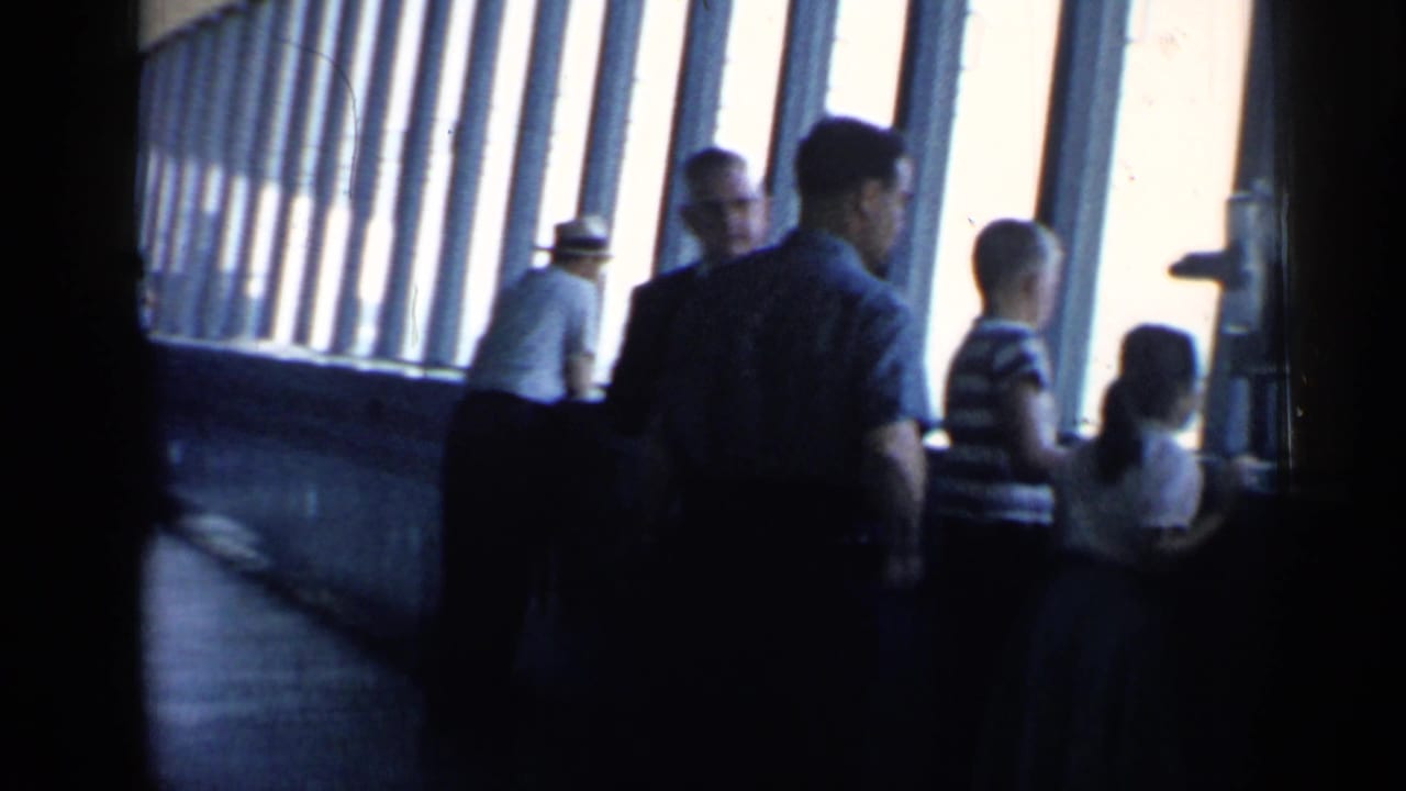 Visitors, including children, stand beside angled windows in a 1958 Chicago public attraction interior.
