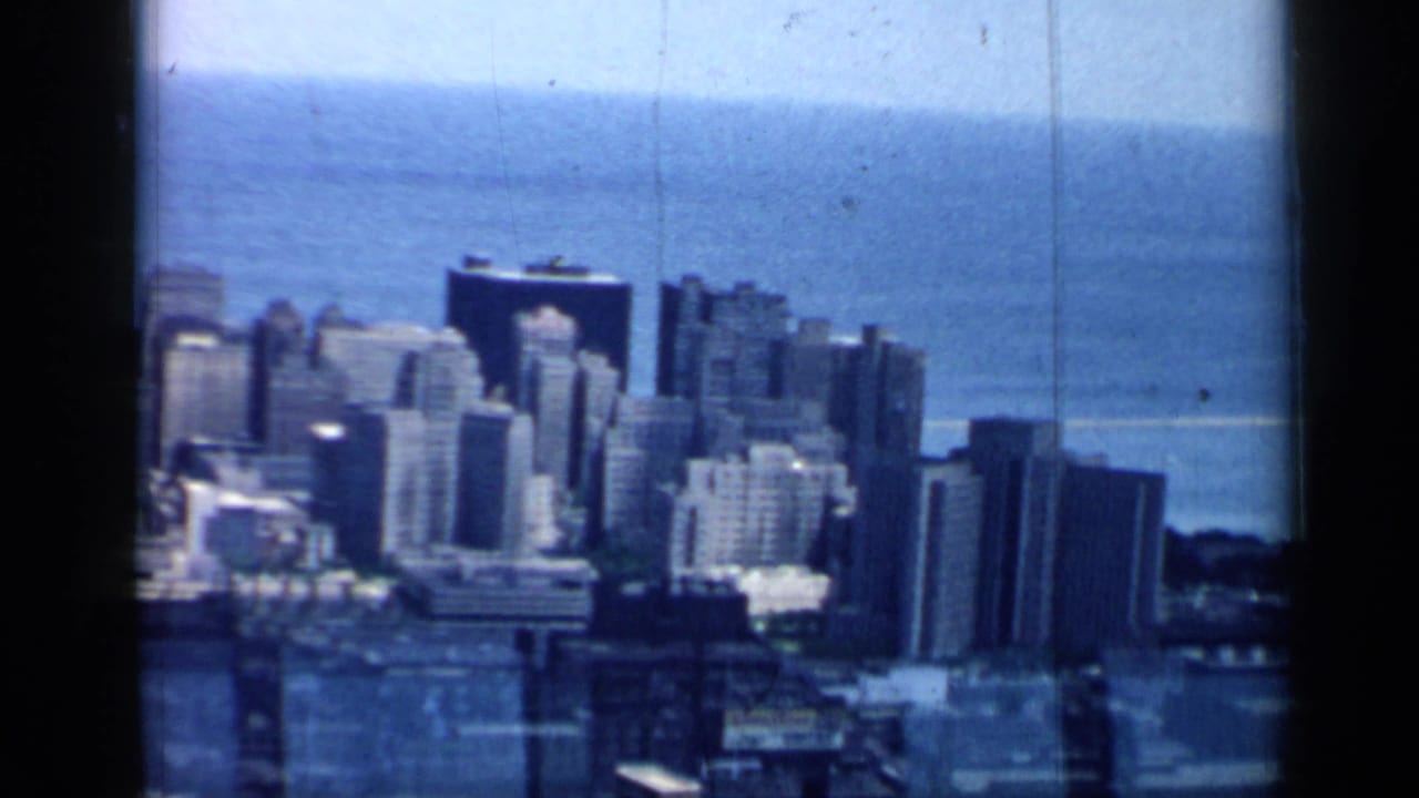 Downtown buildings and lakefront horizon seen through an 8mm film frame.