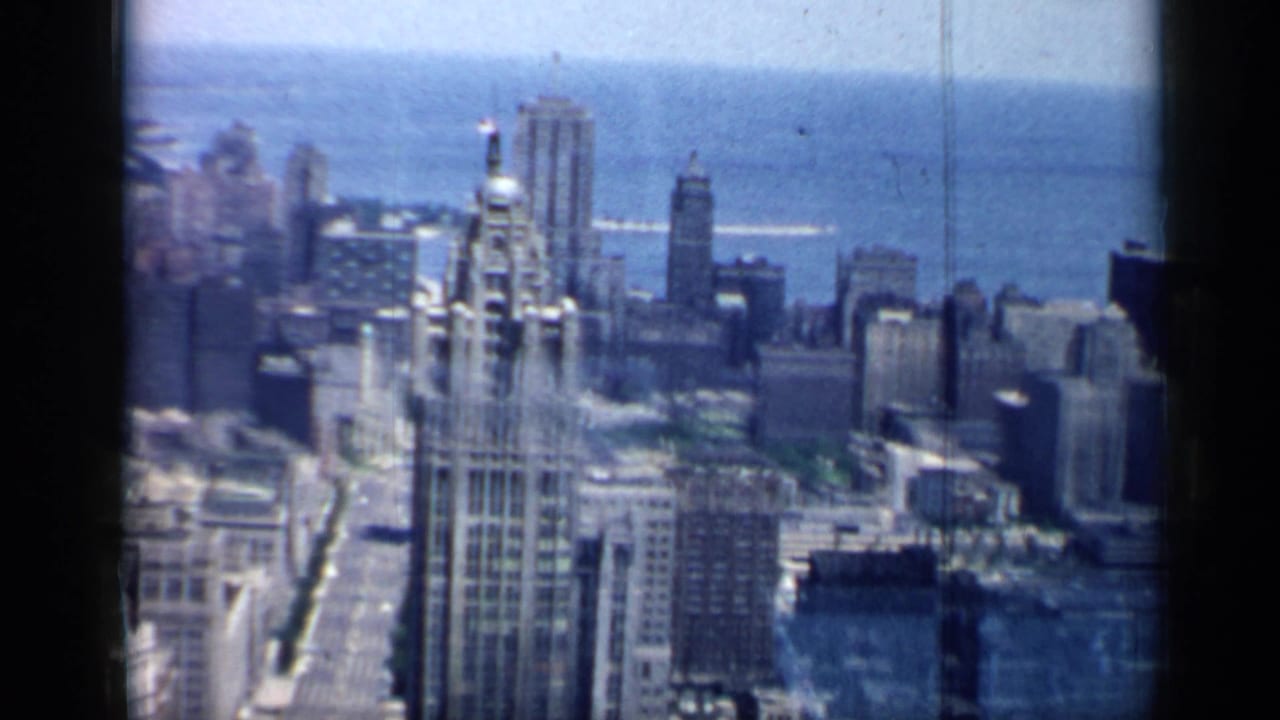 A 1958 high-angle view of Chicago with a prominent historic-looking tower in front of Lake Michigan.