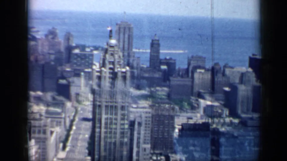 A 1958 high-angle view of Chicago with a prominent historic-looking tower in front of Lake Michigan.