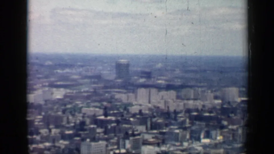1958 Chicago home-movie view across a dense cityscape with distant towers, faded color, and visible 8mm film borders.