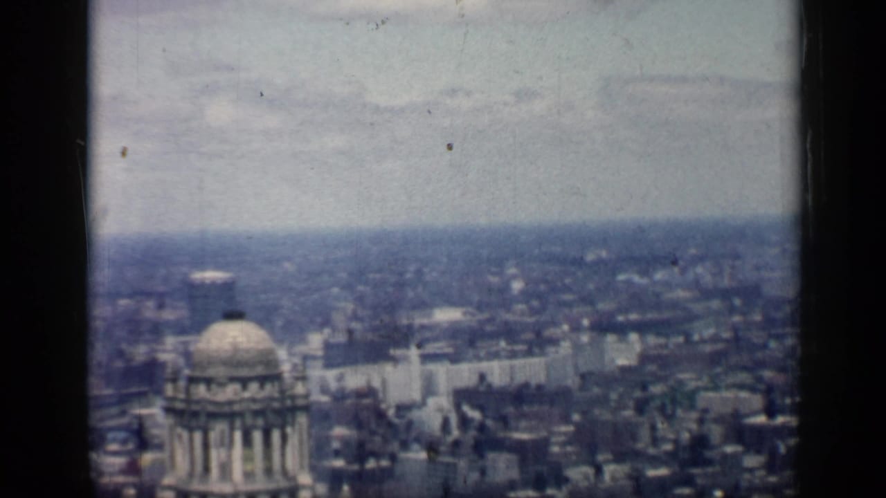 1958 Chicago skyline seen from a high vantage point, with a domed building in the foreground and dark window framing.