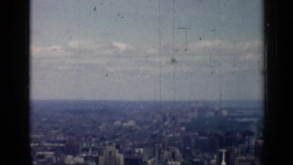 Muted 8mm view over the Chicago skyline, with low contrast, scratches, and a broad cloudy horizon.
