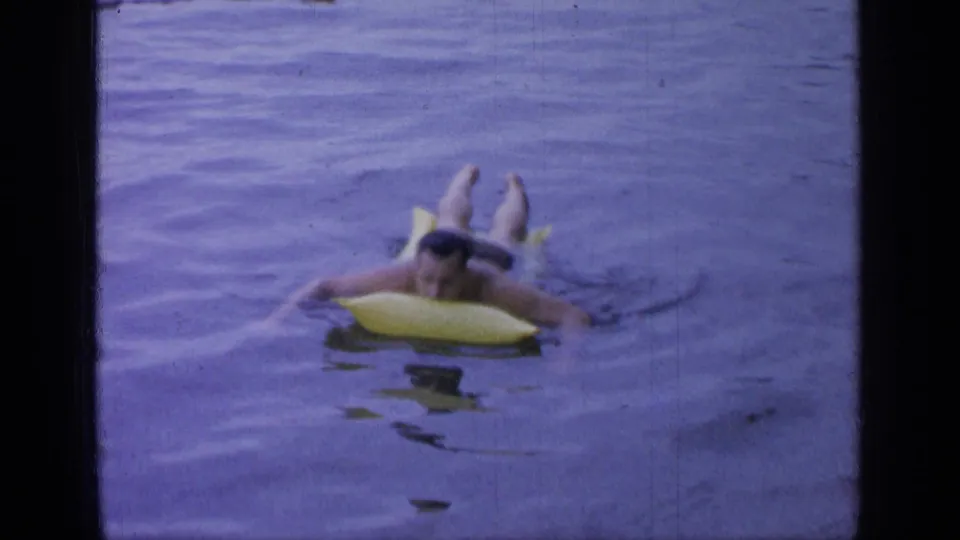 The man stretches across the yellow inflatable raft as he floats through the rippled water at Greenwood Lake.