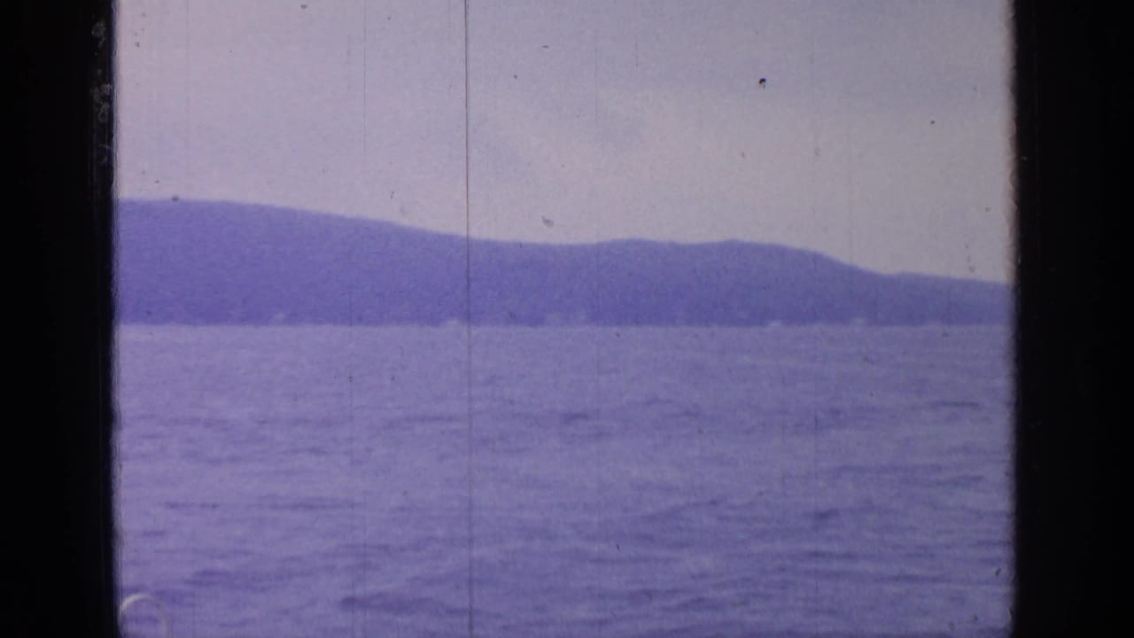 Distant hills and open lake water framed by a dark vertical window divider.