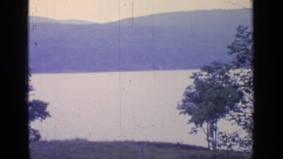 1964 Greenwood Lake view during the pan, showing open water, layered hills, and trees entering at the edges.