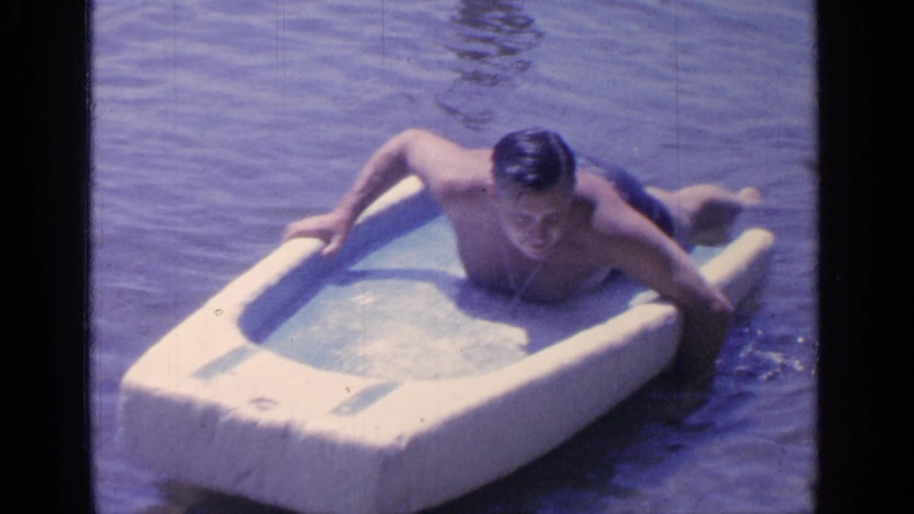 The man appears to adjust his position on the white foam float while floating in Greenwood Lake water.